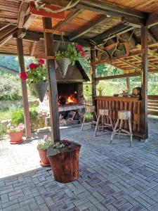 une terrasse avec une cheminée, une table et des chaises dans l'établissement Pansion Savinac, à Takovo