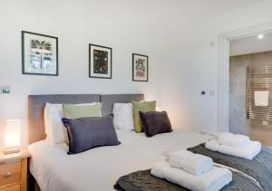 a bedroom with a large white bed with pillows at The Mill in Briston