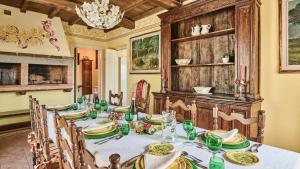 a dining room with a table with green dishes on it at Ribosto in Molazzana