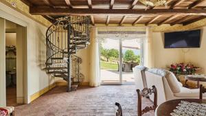 a spiral staircase in a living room with a table at Ribosto in Molazzana