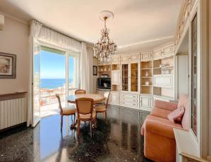 a dining room with a table and chairs and a window at Grande Appartamento Vista Mare in Varazze