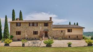 a large stone house with trees and a lawn at Casale Conte Jacopo 10 in Magione