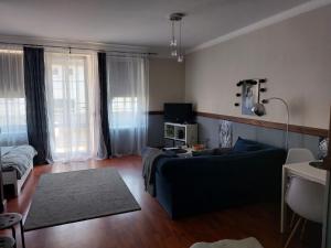 een woonkamer met een bank en een tv bij Apartament Radosna in Gdynia