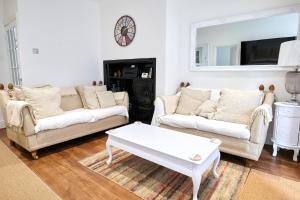 a living room with two couches and a coffee table at Super Stylish Flat Very Close to Freeman Hospital! in High Heaton