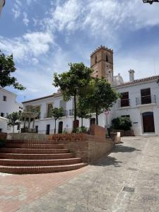 un bâtiment avec une tour d'horloge et des escaliers devant dans l'établissement Casa LA ROMANA, à Salobreña