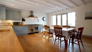 cocina con mesa y sillas en una habitación en Orchard Cottage, Landimore, en Cheriton