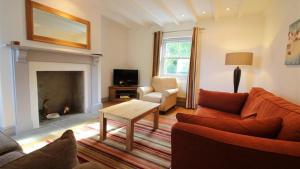 ein Wohnzimmer mit Sofa und Tisch in der Unterkunft Orchard Cottage, Landimore in Cheriton