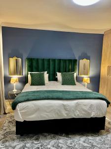 a bedroom with a large bed with a green headboard at 435 on vale boutique aparthotel in Johannesburg