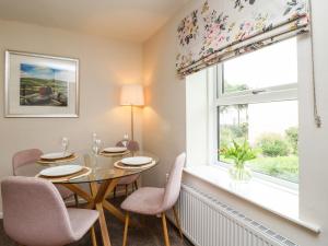 a dining room with a table and chairs and a window at 1 The Old Chapel in Otley