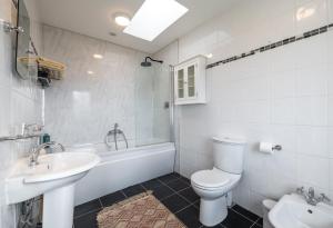 uma casa de banho com um lavatório, um WC e uma banheira em Seahaven em Kenmare
