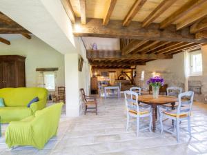 una sala de estar con una mesa y sillas en Moulin Périgourdin : 3 Chambres, Jardin, Rivière et Activités Familiales - FR-1-616-324, en Conne-de-Labarde