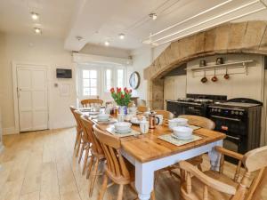a large kitchen with a wooden table and chairs at Hilltop House in Starbotton