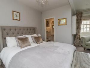 a bedroom with a large white bed with pillows at Hilltop House in Starbotton