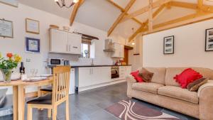 a kitchen and living room with a couch and a table at The Stable, Llanmadoc in Llanmadoc