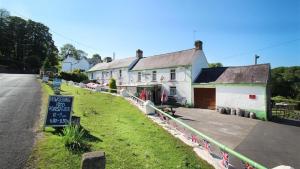 a building with a sign on the side of a road at The Stable, Llanmadoc in Llanmadoc