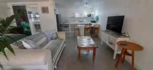 een woonkamer met een bank en een tafel bij Cozy Guest in Graskop