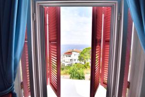 an open window with a view of a house at Noya Köşk Otel in Adalar