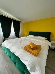a bedroom with a large bed with two towels on it at Sunset Expanse in Turda