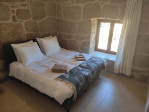 uma cama com duas toalhas num quarto com uma janela em Quinta da Adarnela em Lagares da Beira