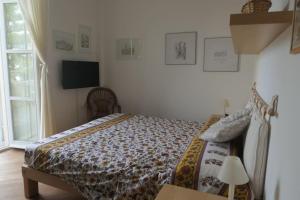 een slaapkamer met een bed en een tv aan de muur bij Loft Bellevue - Seaview - WiFi in Menton