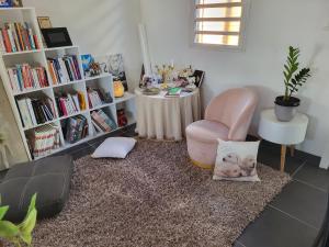 een woonkamer met een roze stoel en een tafel bij LA KAZ A DIAMANTS in Saint-Denis