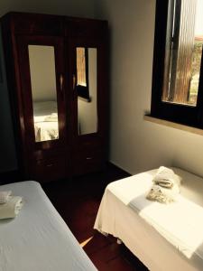 a room with two beds and a cabinet with a mirror at Villa Mara in San Lorenzo