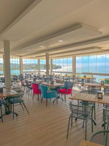 un restaurant vide avec des tables, des chaises et des fenêtres dans l'établissement Mercan Otel, à Çanakkale