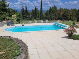una piscina en un patio con patio en B&B BonjourSoleil en Tourouzelle