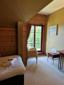 - une chambre avec un lit, une chaise et une fenêtre dans l'établissement Green bear, à Līgatne