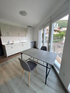 eine Küche mit einem Tisch und Stühlen im Zimmer in der Unterkunft UpART House in Petrovac na Moru
