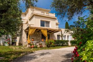 a large house with yellow curtains on a driveway at Dion Mari in Fiolítis