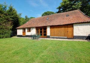 a small house with a grassy yard in front of it at Rectory Barn in Ashwellthorpe