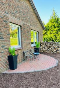 a brick building with a table and chairs on a brick patio at Diek Hus in Dorum-Neufeld