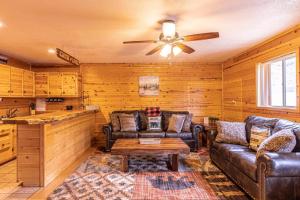 ein Wohnzimmer mit Ledermöbeln und einem Deckenventilator in der Unterkunft Cabin #6 Bobcat Bunkhouse - Pet Friendly - King Bed - Sleeps 4 in Payson