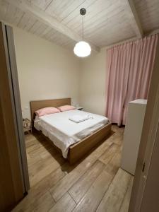 ein Schlafzimmer mit einem Bett und einem rosa Vorhang in der Unterkunft Sea apartments2 in Terracina
