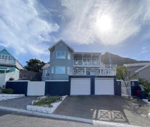 a blue house with a balcony and a garage at Villa Amanzi in Hout Bay