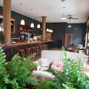 um restaurante com um sofá e um bar com um balcão em Hostal Tastavins em Peñarroya de Tastavins