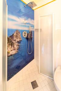 a bathroom with a shower with a painting of the ocean at Hotel Capri 3 Stelle SUPERIOR in Lido di Jesolo