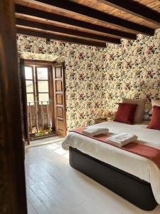 1 dormitorio con 1 cama grande con flores en la pared en Casagrande Don Pedro, en Cóbreces