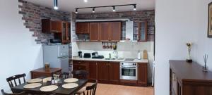 een keuken met een tafel en een bakstenen muur bij Semiramida gardens Apartment 23 in Borovets