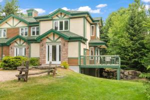 a large house with a green roof at Townhouse On The Golf W Pool Access -aiglon 1748 in Mont-Tremblant
