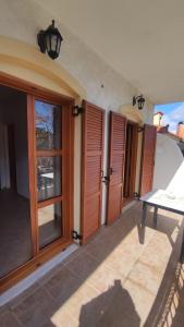 Zimmer mit Holztüren und einem Tisch auf der Terrasse in der Unterkunft Niko's Apartments A1 in Gialiskari