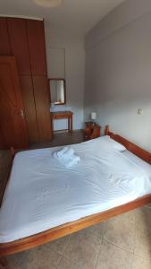 Una cama con sábanas blancas y dos toallas. en Niko's Apartments A1, en Gialiskari