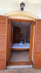 una porta aperta che conduce a una camera con letto di Niko's Apartments A1 a Gialiskari