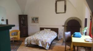a bedroom with a bed and a table and a chair at Schloss Höllrich in Karsbach