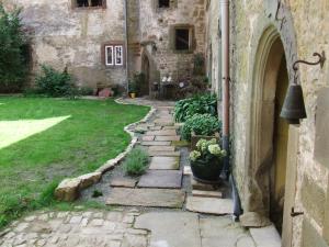 a stone path in front of a building with a yard at Schloss Höllrich in Karsbach