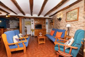 sala de estar con sillas azules y sofá azul en Casas rurales LA LAGUNA y LA BUHARDILLA DE LA LAGUNA, en Gallocanta
