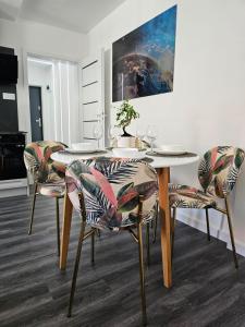 a dining room with a white table and chairs at Galaxy Apartments 2 in Słupsk