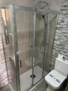 a bathroom with a glass shower with a toilet at Hotel Argibay in O Grove