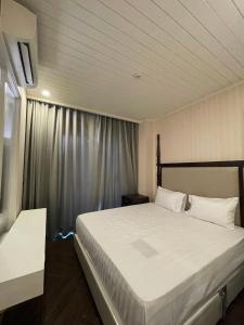 um quarto com uma grande cama branca e uma janela em Grand Florida BeachFront Resort NaJomtien Pattaya em Na Jomtien